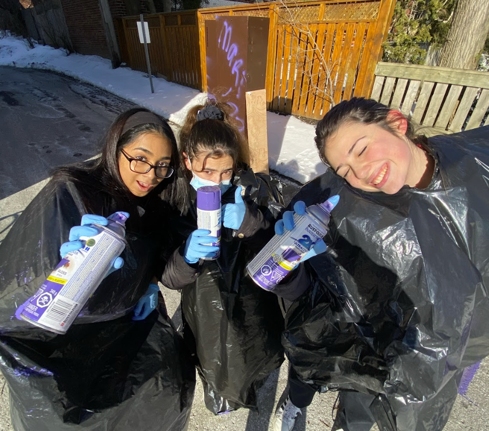 Andrea, Nehna et Zoe peinturent des casiers avec de la peinture en spray