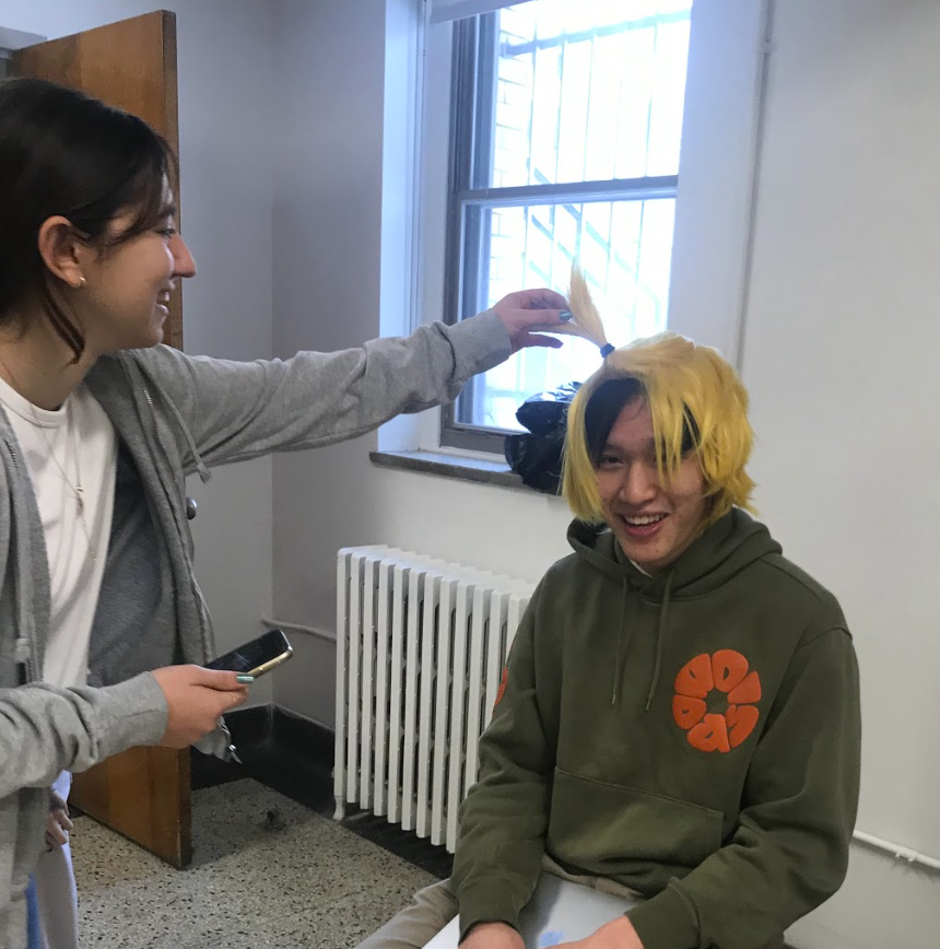 Andrea fixing the blond wig on Yau