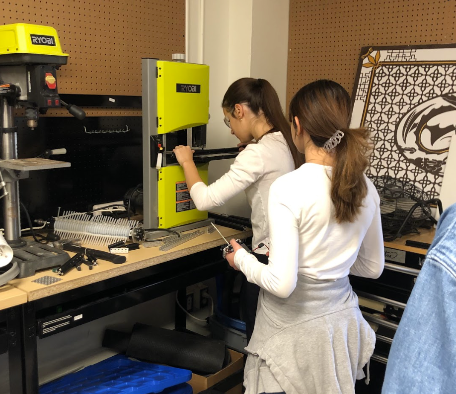 A team member drilling a piece of metal